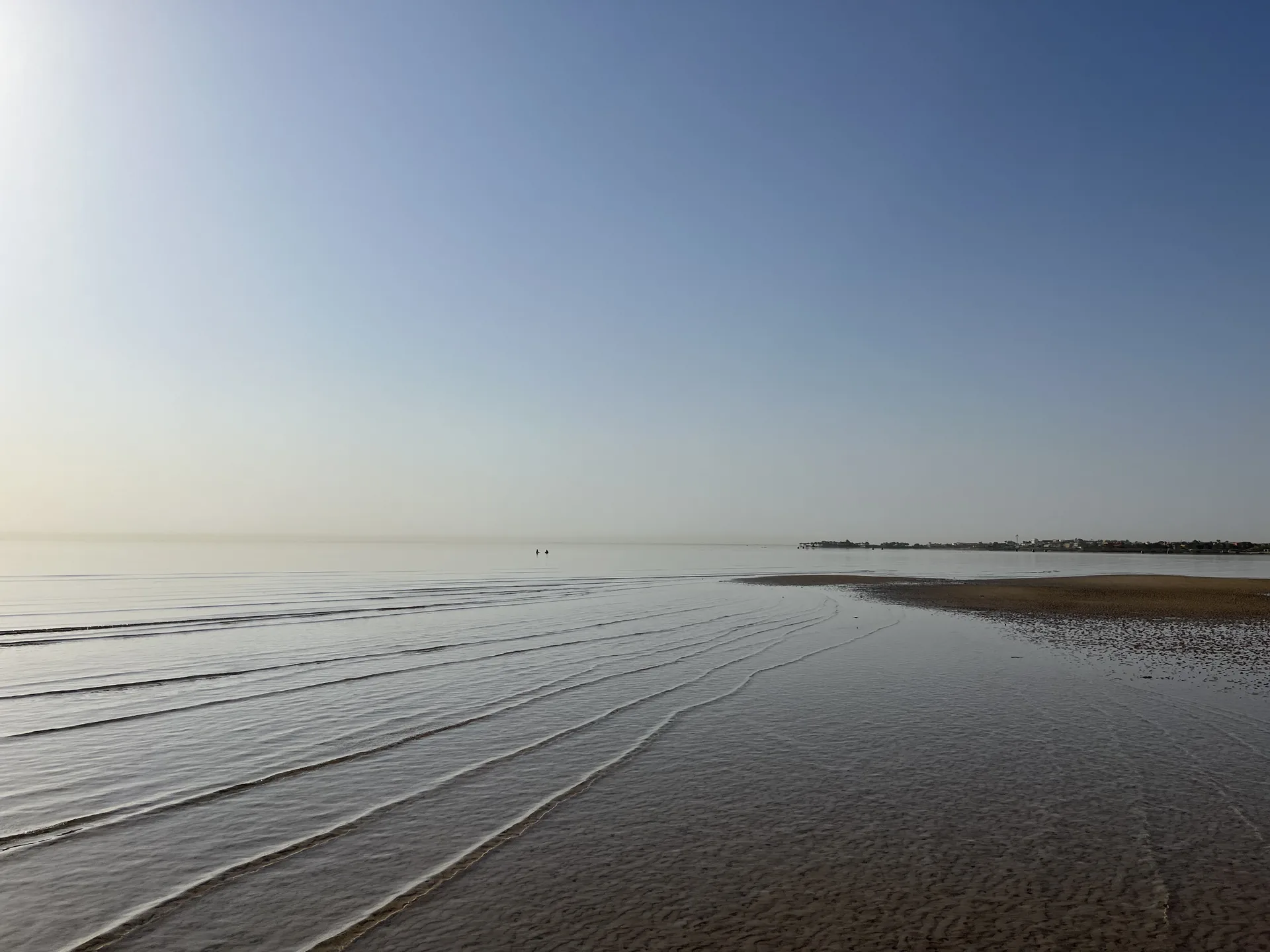 Low tide shoreline, diagonal waves and open sky